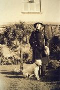 M55 Mrs J Newbould WVS, with dog, in garden of her house.