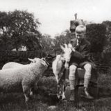 M62 Rowland Unwin sitting on the village pump with sheep and goat, on 